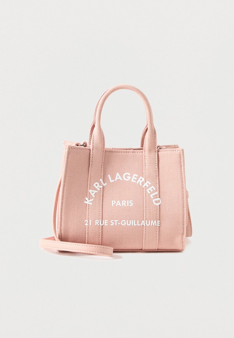 Ροζ τσάντα tote από καμβά Karl Lagerfeld με διπλές λαβές, λευκό κείμενο «KARL LAGERFELD PARIS 21 RUE ST-GUILLAUME» και αποσπώμενο ιμάντα ώμου.