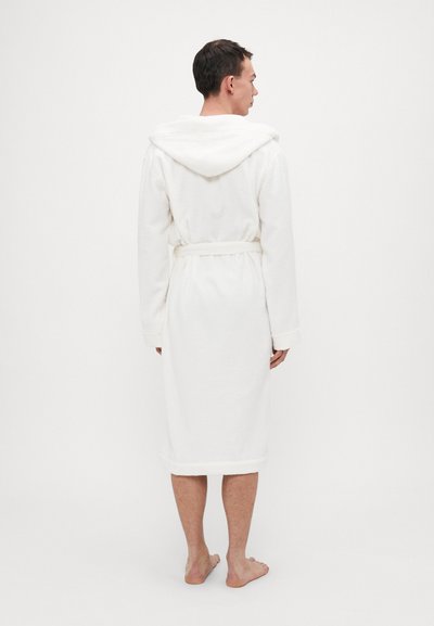 White bathrobe made of plush terry cloth, featuring a hood, long sleeves, and a matching waist tie, reaching mid-calf, soft texture.