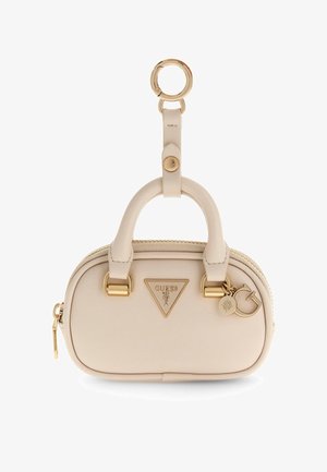 Small beige leather handbag with double handles, gold-tone hardware, zipper closure, and Guess logo with attached charms and keyring.