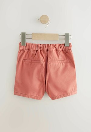 Persikofärgade shorts i smidigt tyg, med resårmidja och två bakfickor. Hänger på en träklämma.