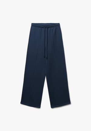 Pantaloni tuta blu navy con vita regolabile, gamba larga e cuciture verticali. Realizzati in tessuto morbido e testurizzato.