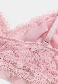 Pink lace bralette featuring floral patterns, delicate scalloped edges, and soft fabric. Includes adjustable straps and a smooth lining.