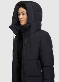 Chaqueta de plumas azul marino con una capucha grande, diseño acolchado, cierre de cremallera, detalles con cordón y bolsillos laterales. Textura suave y aislante.