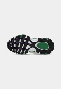Semelle de sneaker Lacoste avec une base en caoutchouc noir et des accents verts, violets et blancs ; texturée pour une meilleure adhérence et stabilité.