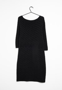 Abito nero lavorato a maglia appeso, con una trama ondulata, maniche lunghe e scollatura rotonda. Il tessuto appare morbido ed elastico.