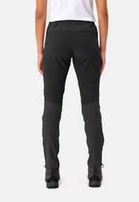 Zwarte outdoorbroek met een gestroomlijnde pasvorm, voorzien van contrasterende lichtere panelen op de knieën. Duurzaam materiaal met een gladde textuur.