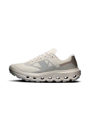 Chaussure de running beige clair avec tige en mesh respirant, fermeture à lacets et semelle coussinée munie de trous en forme de nuage pour l'absorption des chocs.