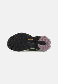 Semelle de chaussure avec un design en caoutchouc noir et violet robuste, présentant des motifs de crampons mult方向nels et un logo Continental visible.