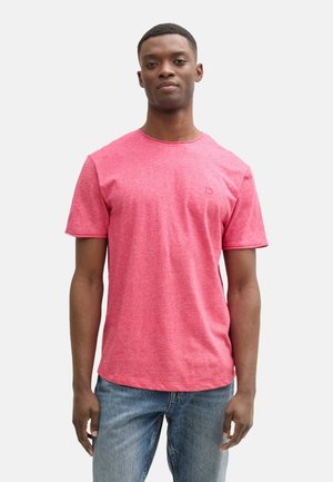 Rode heide t-shirt met korte mouwen en ronde hals, voorzien van een subtiele logo op de borst en een casual pasvorm, gecombineerd met lichtblauwe jeans.
