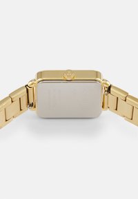Gold metal watch with a rectangular case, smooth finish, and a matching link bracelet. Features a textured crown and brushed back with engravings.