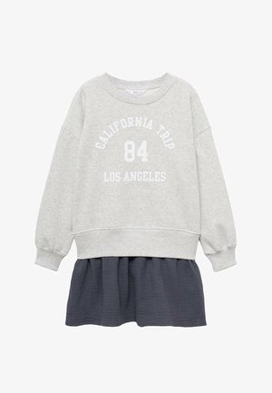 Hellgrauer Pullover mit weißem Text "CALIFORNIA TRIP 84 LOS ANGELES", kombiniert mit einem dunkelgrauen, strukturierten, geschichteten Rock.