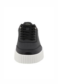 Fekete bőr sportcipő kerek orral, texturált fehér gumitalppal és hagyományos fűzős dizájnnal, amely perforált részletekkel rendelkezik a felsőrészén.