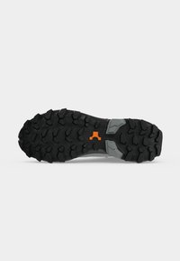 Semelle de chaussure noire robuste avec des crampons profonds pour la traction, avec des accents gris et un petit logo orange au centre.