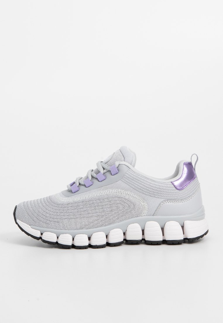 Scarpa sportiva grigia con tomaia in rete testurizzata, accenti viola e una suola bianca spessa con dettagli neri. Design della punta arrotondata.