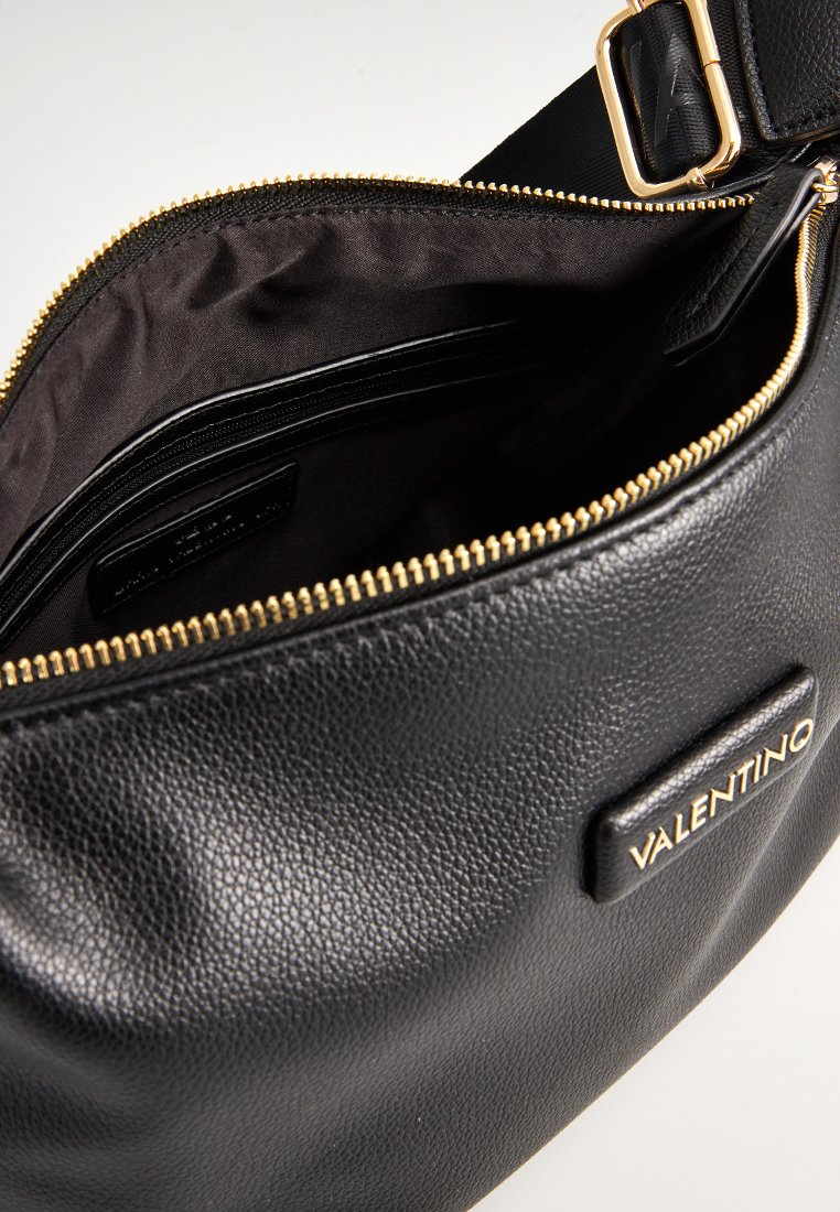 Bolso de hombro de cuero negro con una superficie texturizada, cremallera de hardware dorado y un interior de tela oscura con múltiples compartimentos.