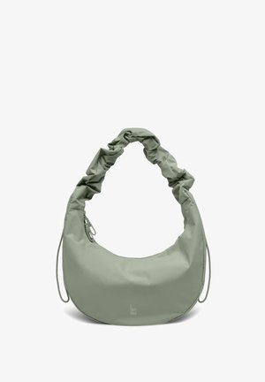 Sac à épaule vert clair en forme de croissant avec bandoulière froncée et poche zippée, logo "GOT BAG" au centre devant.