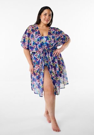 Floral printed kimono cover-up in sheer, lightweight fabric. Features short sleeves, a tie waist, and vibrant hues of purple, pink, and green.