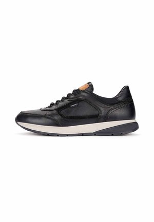 Zapatilla negra de cuero con suela blanca, perfil bajo, cierre de cordones en la parte delantera y pequeño logo en el lateral, mostrada de perfil sobre fondo blanco.