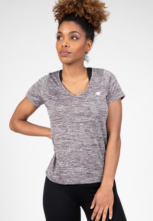 Korte mouw sportshirt van heather grijze stof, met een V-hals ontwerp en een klein logo op de borst, gecombineerd met zwarte leggings.