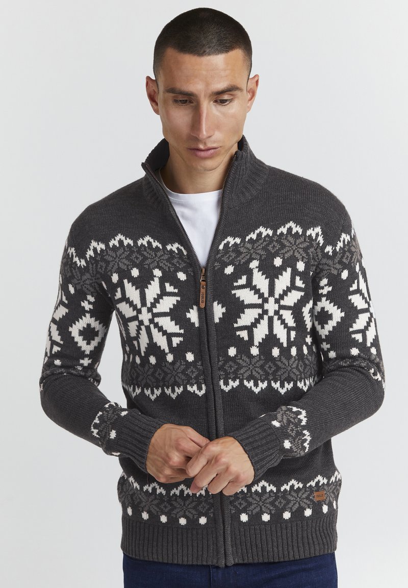 Grauer Reißverschluss-Pullover mit weißen Schneeflockenmustern, gerippten Bündchen und Saum; ausgestattet mit einem Holz-Reißverschluss-Zipper und einem kleinen Markenlabel am Saum.