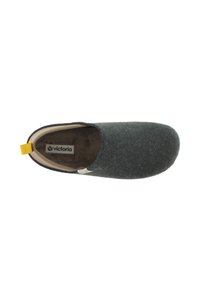 Zapato gris de tela tipo slip-on con punta redondeada, forro crema y un pequeño acento amarillo en el talón. Diseño minimalista, textura suave.