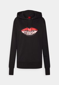 Czarna bluza z kapturem z dużym graficznym nadrukiem czerwonych ust i słowem "HUGO" w wyraźnej czcionce. Kaptur z sznurkami i ściągaczami na rękawach.