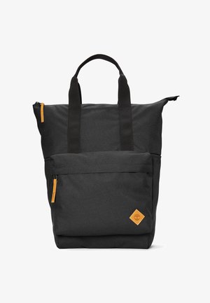 Zwarte stoffen rugzak met twee handvatten, contrasterende oranje ritssluitingen, een voorzak en een kleine tan kleurige logo patch. Gestructureerd ontwerp.