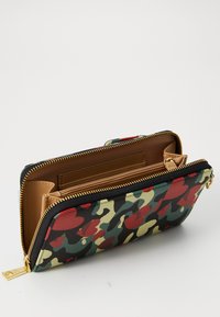 Camouflage-patterned wallet in green, red, and beige. Made of textured material with a brown interior, featuring a gold zipper and accents.