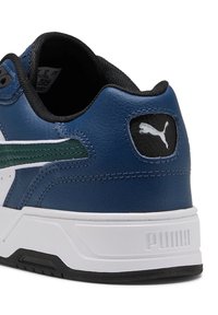 Blaue Ledersneaker mit weißer Sohle. Merkmale sind ein grüner Akzentstreifen, ein schwarzes Fersen-Patch mit weißem Logo. Texturierte Oberfläche und gepolsterter Kragen.
