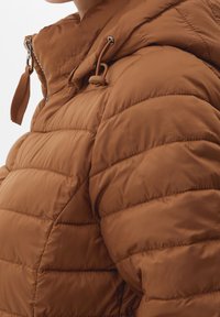 Hnědá péřová bunda s prošívanou texturou, obsahující zip, kapuci na stahování a akcenty s uzávěry. Materiál je hladký a matný.