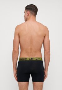 Fekete nylon boxer alsónadrág, textúrázott lime zöld és fekete márkás derékszíjjal, testhezálló kialakítással és sima felülettel.