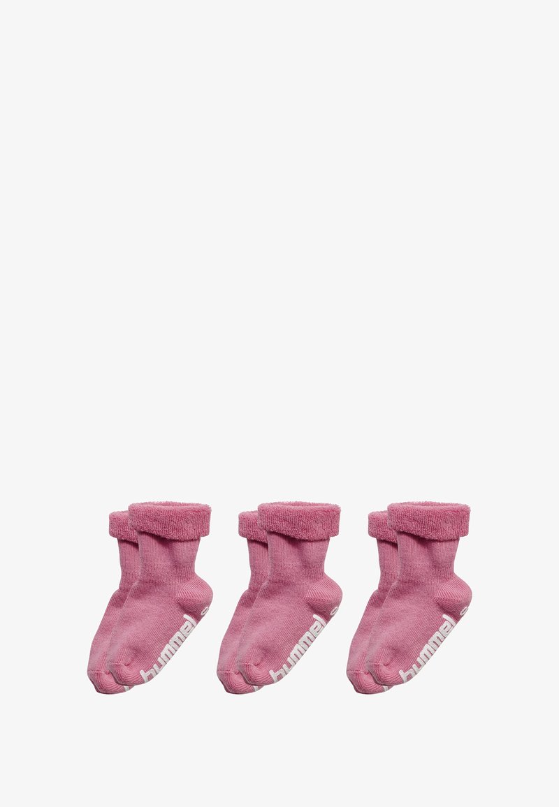 Trois paires de chaussettes de cheville roses avec un poignet duveteux, arborant une marque blanche sur le côté. Matériau doux, texture côtelée et orteils arrondis.