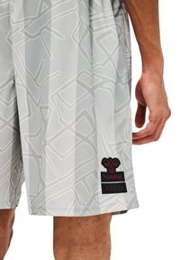 Grå idrottsshorts med en geometrisk mönster, tillverkade av lätt material. Har en svart och röd "hummel HALO" logotyp patch.