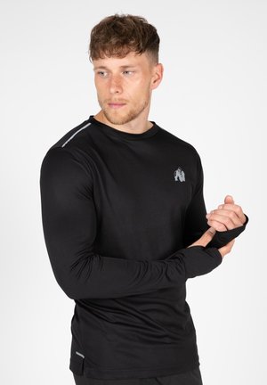 Zwarte sportshirt met lange mouwen, met een aansluitende pasvorm, ronde halslijn, grijze accent langs de schouder en logo op de borst.
