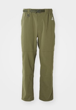 Olivengrüne, leichte Hose mit elastischem Bund, verstellbarem Gürtel und gesteppten Akzenten. Mit einem Logo an der Oberschenkeloberseite.