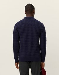 Sweater de tricô azul marinho com um padrão de grade texturizado, apresentando um decote com gola e punhos canelados, visto de costas.