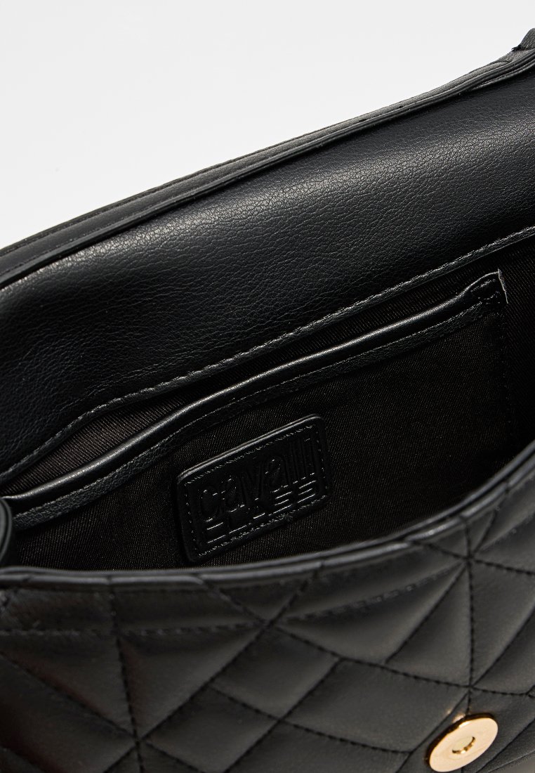 Bolso de mano de cuero negro acolchado abierto para mostrar el bolsillo interior con la etiqueta de la marca Calvani y cierre magnético dorado.