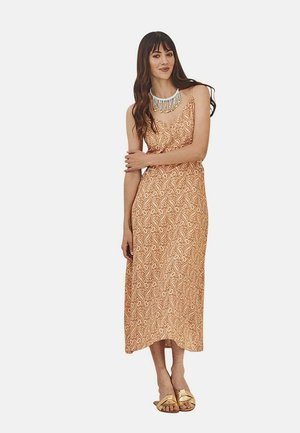 Vestido maxi de tela melocotón con un patrón de paisley; diseño sin mangas, ligera forma en A, complementado con un collar de cuentas y sandalias doradas.