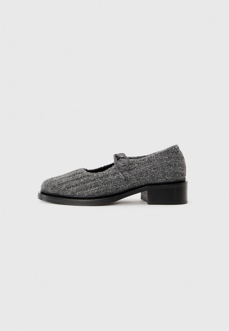Gray knit Mary Jane shoe with low block heel and black sole, featuring a single looped strap on a plain white background.