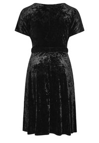 Černé sametové šaty s uvolněným střihem, krátkými rukávy a rozšířenou sukní. Mají odpovídající pás na pásu a hladkou strukturu.