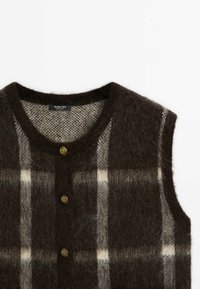 Brown and gray checkered vest made of soft, fluffy material. Features a round neckline and gold buttons. Textured pattern throughout.