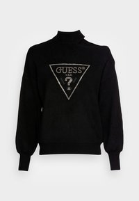 Zwarte trui met een hoge kraag, verlengde schouders en elastische mouwen; heeft een zilveren driehoekig logo met een vraagteken en de tekst "GUESS".