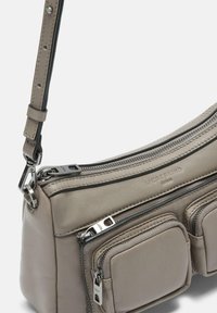 Borsa a spalla in pelle grigia con molteplici tasche con zip, una texture liscia e una tracolla rimovibile; presenta dettagli in metallo argentato.
