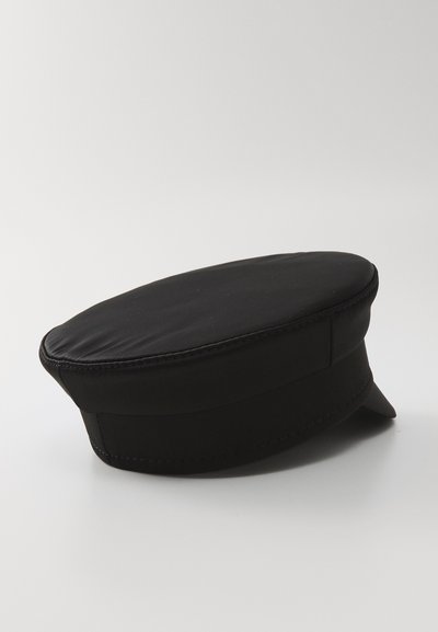 Mustvalge flat-top meremehe stiilis kork väikese jäiga äärega, esitletud valge pinna peal.