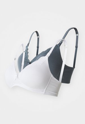 Kaksi rintaliiviä: yksi valkoinen pitsiyksityiskohdilla, toinen tummanharmaa, molemmat säädettävillä olkaimilla ja pehmeällä, sileällä kankaalla.