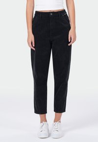 Zwarte corduroy cropped broek met een rechte pasvorm, voorzien van zakken aan de voorkant en een knoopsluiting, gecombineerd met witte sneakers.