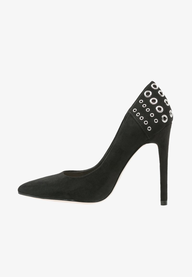 Chaussure à talon haut stilettos en daim noir avec bout pointu et détails métalliques d'œillets autour de la zone du talon.