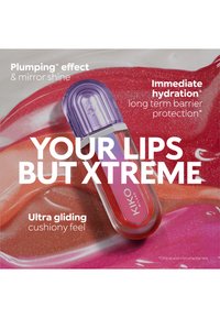 Lipglosstube med lilla lokk på blanke røde, oransje og rosa leppefargeprøver, som fremhever fuktighet, fyldighet og glideeffekter.