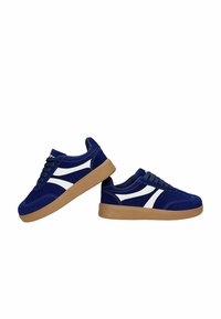 Paire de baskets bleu foncé avec des bandes blanches et des semelles marron, présentées côte à côte sur fond blanc.
