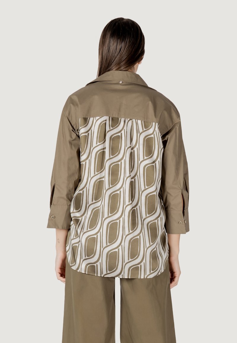 Camicia a maniche lunghe con il davanti color khaki e il retro con motivo che presenta disegni geometrici bianchi e beige. Realizzata in un tessuto liscio con colletto.